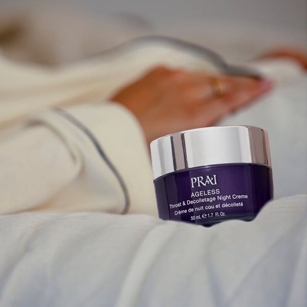 PRAI Beauty Ageless Throat and Decolletage Creme Night on a bedsheet