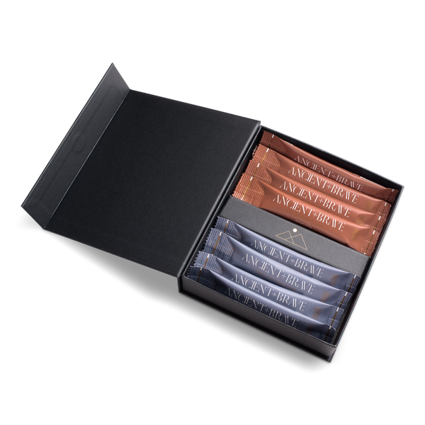 An open black gift box containing several small rectangular packets or sachets labeled ANCIENT BRAVE, arranged in two rows on a clean white background.