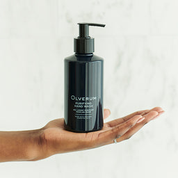 Olverum Purifying Hand Wash held in the palm of a hand