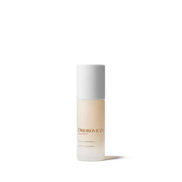 Omorovicza Daily Vitamin C Tinted Moisturizer bottle, featuring a frosted glass bottle showing the beige-tinted liquid inside, a white cap, and gold lettering on a clean white background.