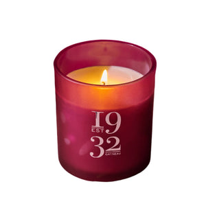 Pink candle in a glass holder with '1932 Gatineau' text on a pink background