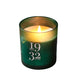 Green candle with '1932 Gatineau' branding on a reflective surface with confetti.