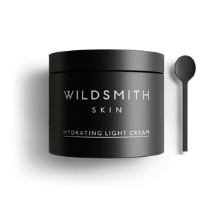 Black jar of Wildsmith Skin hydrating light cream with a spoon on a white background