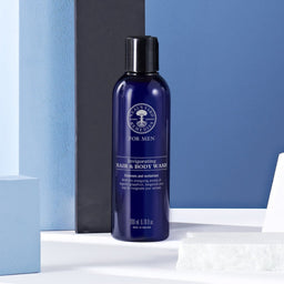 Neal's Yard Invigorating Hair & Body Wash bottle in front o a blue background