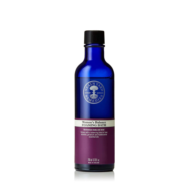 A blue bottle of Neal's Yard Remedies Women's Balance Foaming Bath with a label showing the brand logo and product information.