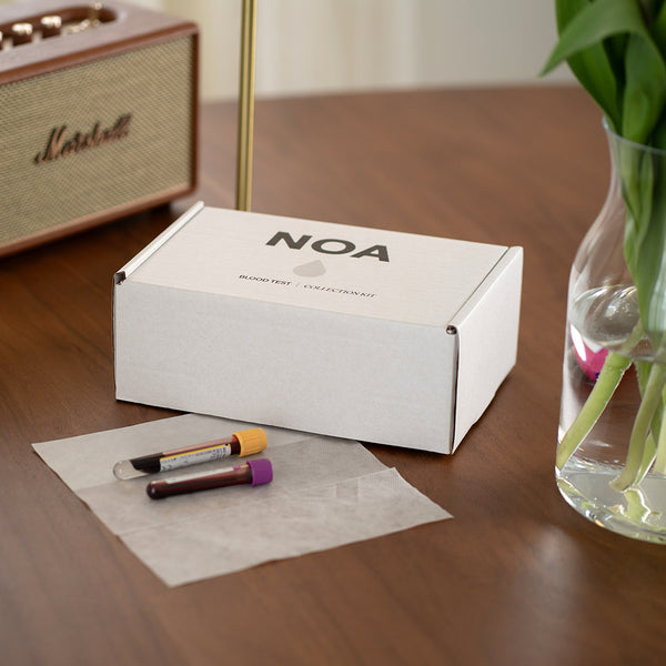 NOA box on a wooden table with test tubes and a plant
