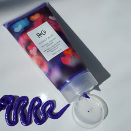 a tube of R+Co Sunset Blvd Blonde Toning Masque with its purple contents laid next to it