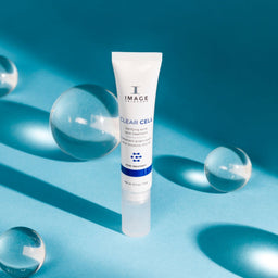 Image Skincare Clear Cell Clarifying Blemish Treatment placed on  a blue surface with 4 clear orbs surrounding it
