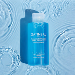 a bottle of Gatineau Floracil Eye Makeup Remover laying in a puddle shallow water