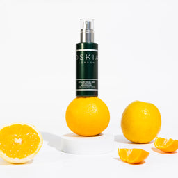 OSKIA CityLife Facial Mist bottle on top of an orange