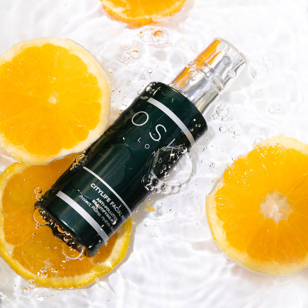 OSKIA CityLife Facial Mist placed in water with slices of oranges