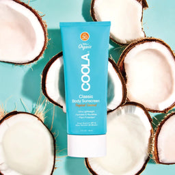 COOLA Body Lotion SPF30 Coconut on top of halved coconuts 
