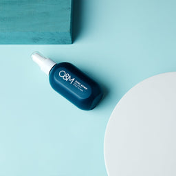 O&M Surf Bomb bottle on a blue surface
