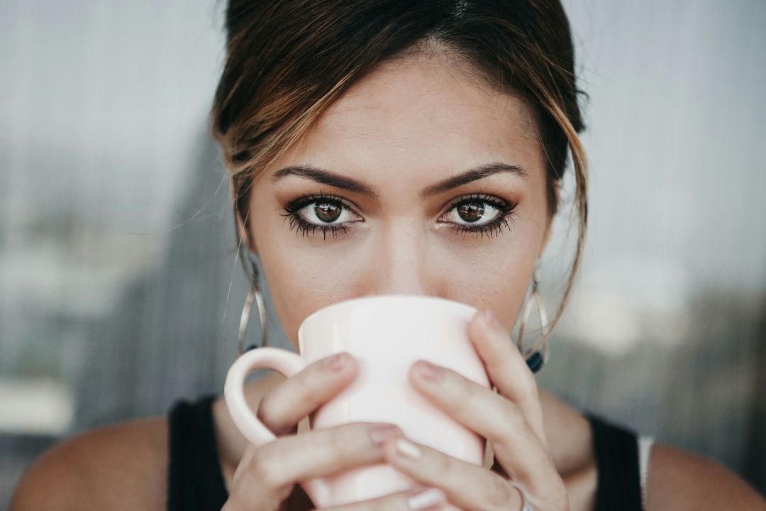 woman holding tea cup up to her face