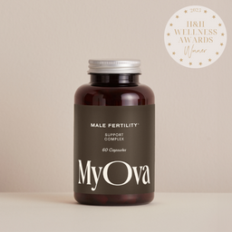 A dark amber bottle of MyOva Male Fertility Support Complex with a dark brown label and silver cap, set against a warm beige background. A white circular award badge for 'I&I Wellness Awards Winner 2025' is in the top right corner.