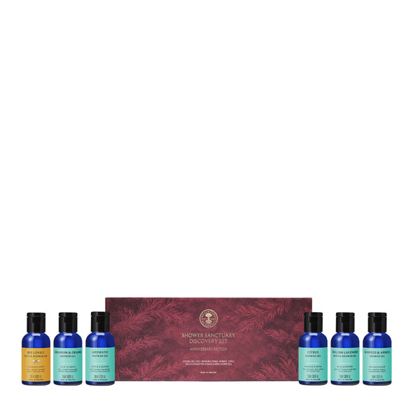 Shower Sanctuary Discovery Set featuring a red patterned gift box with six small travel-sized bottles in blue, yellow, and mint green arranged in front on a white background.