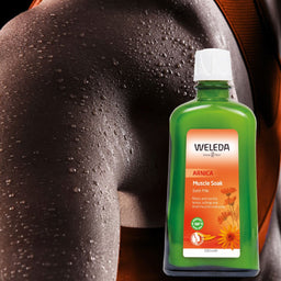 A bottle of Weleda Arnica Muscle Soak bath milk shown in front of a close-up of a sweating human back, indicating its use for muscle relief and skin care.