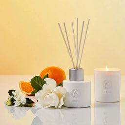 ESPA Positivity Reed Diffuser next to a lit candle 