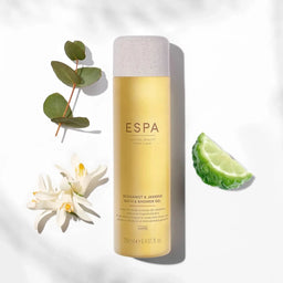 ESPA Bergamot & Jasmine Bath & Shower Gel bottle with a slice of lime and flowers next to it