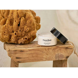 Natura Bisse Diamond Well-Living The Body Cream on a wooden chair