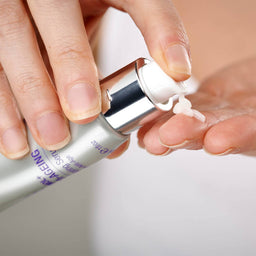 a hand squeezing the serum into a hand