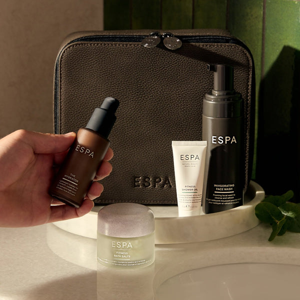 a hand taking a bottle of serum from the ESPA Winter Wellness Men’s Collection
