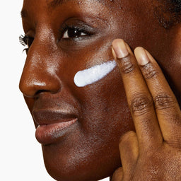 Model applying CeraVe Facial Moisturising Lotion to their face