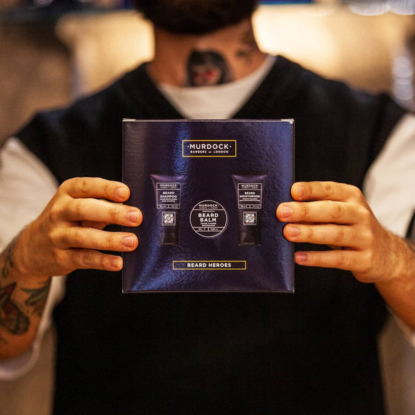 a man with neck and arm tattoos holding the Murdock London Beard Heroes