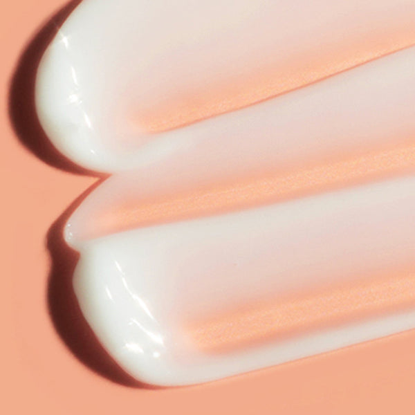 Close-up of white cream on a peach-colored background