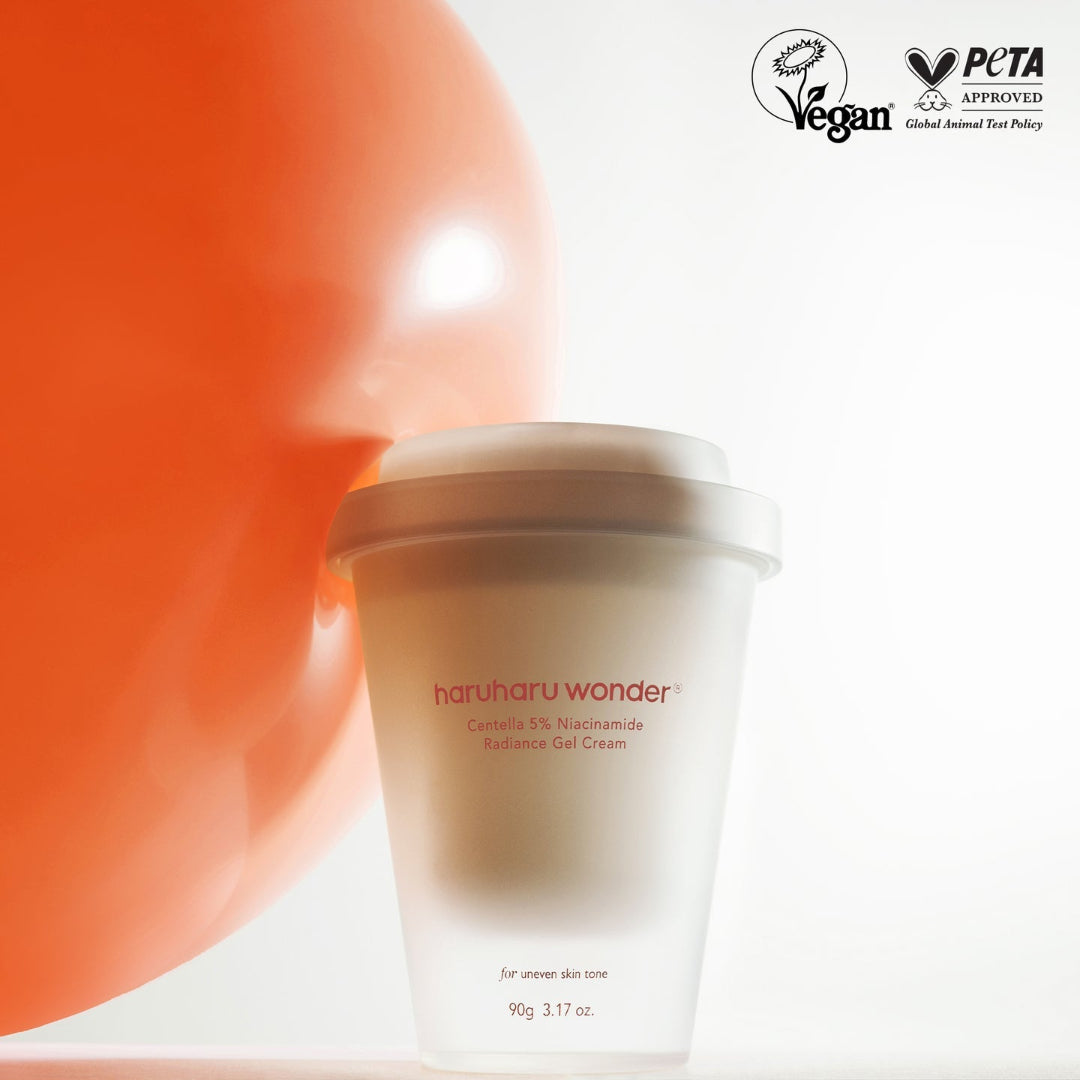 A frosted cosmetic cup labeled 'haruharu wonder' with red text, shown on a white background with a large orange balloon behind it. Vegan and PCTA Approved logos appear in the top right.