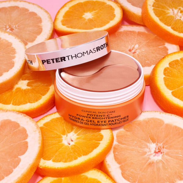 Peter Thomas Roth Potent-C Power Brightening Hydra-Gel Eye Patches tub on a bed of sliced oranges