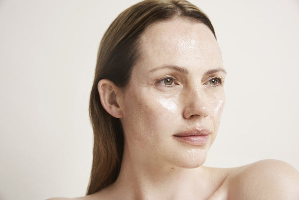 a closeup of a women with the cream applied to her face