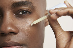 a closeup of a man applying the tincture to his face