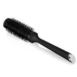 Black hairbrush with silver ferrule on a white background