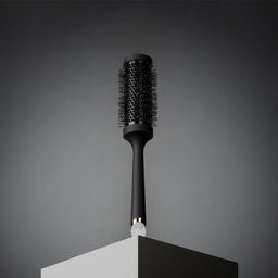 Black hairbrush on a gray background