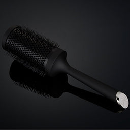 Black hairbrush on a dark background