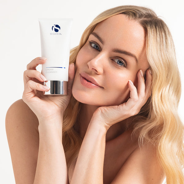 Woman holding a skincare product with a white background