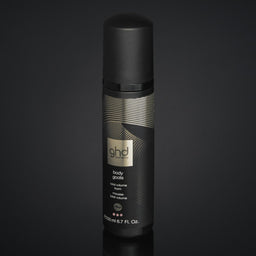 Black spray bottle with a label on a dark background