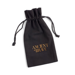 A black drawstring pouch with the words 'ANCIENT * BRAVE' printed in gold on the front, shown on a plain white background.