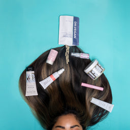 Person with hair products on a turquoise background