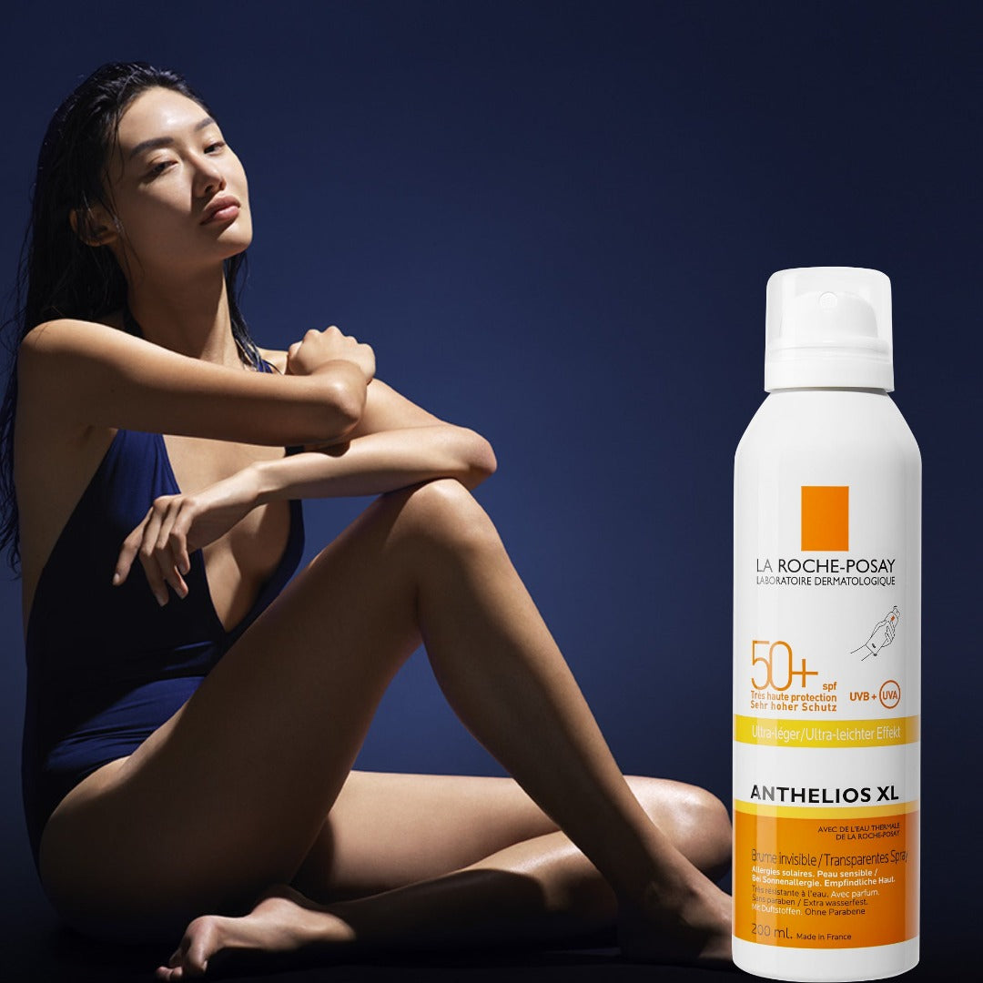 Model sat next to a bottle of the body mist