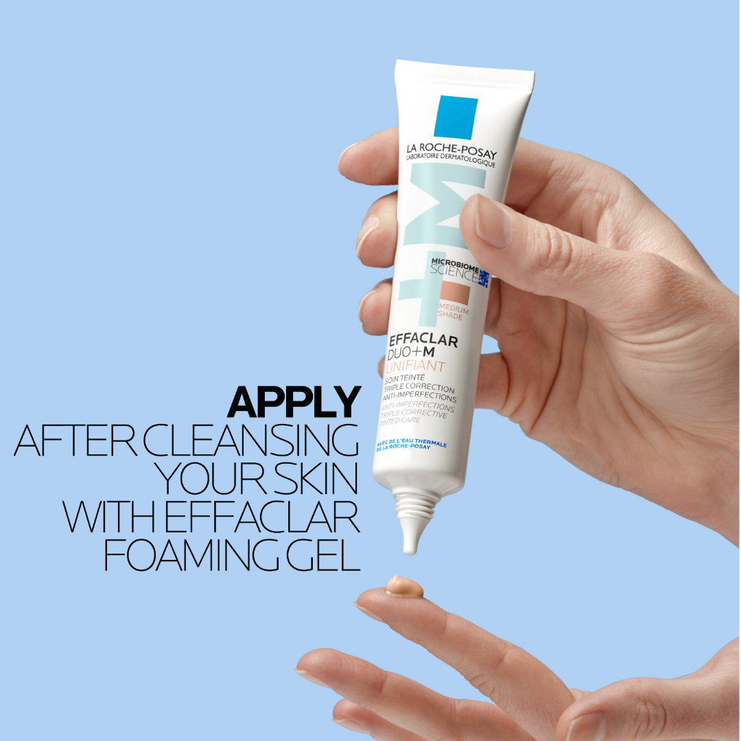 Hand holding a tube of La Roche-Posay Effaclar product with text on a light blue background