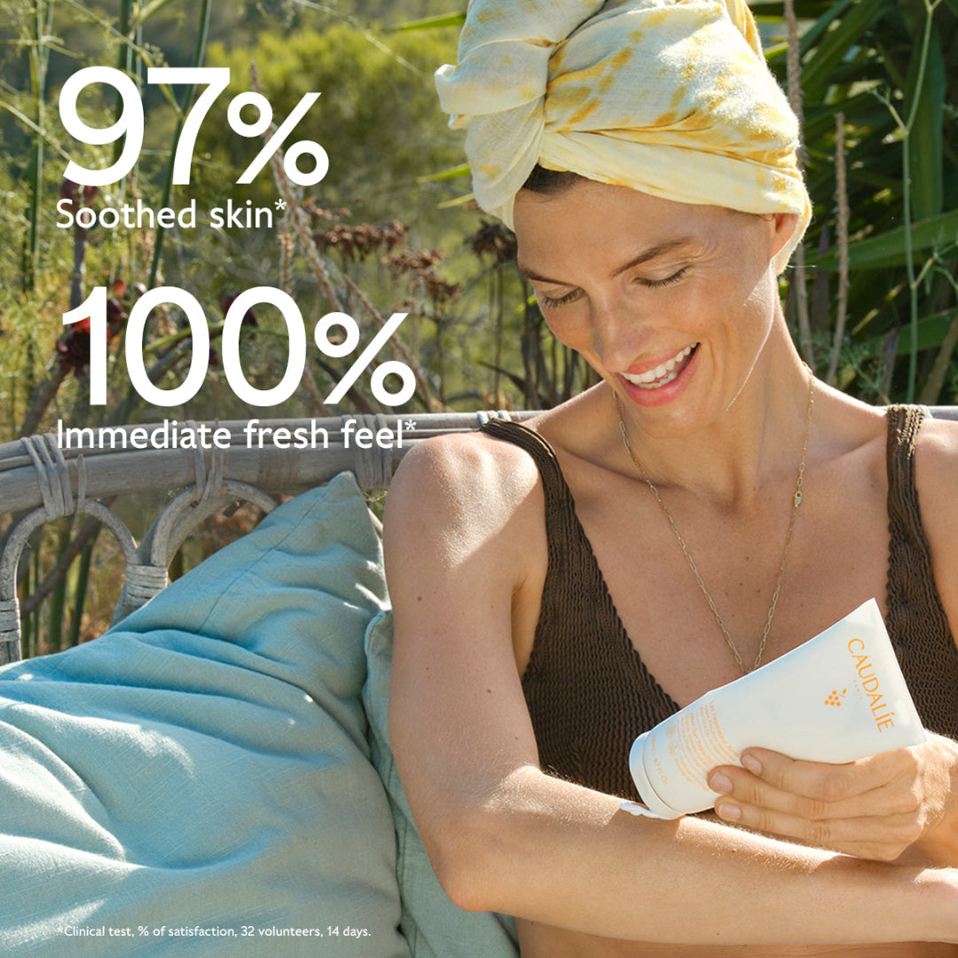 Woman applying sunscreen with a product container, surrounded by nature.