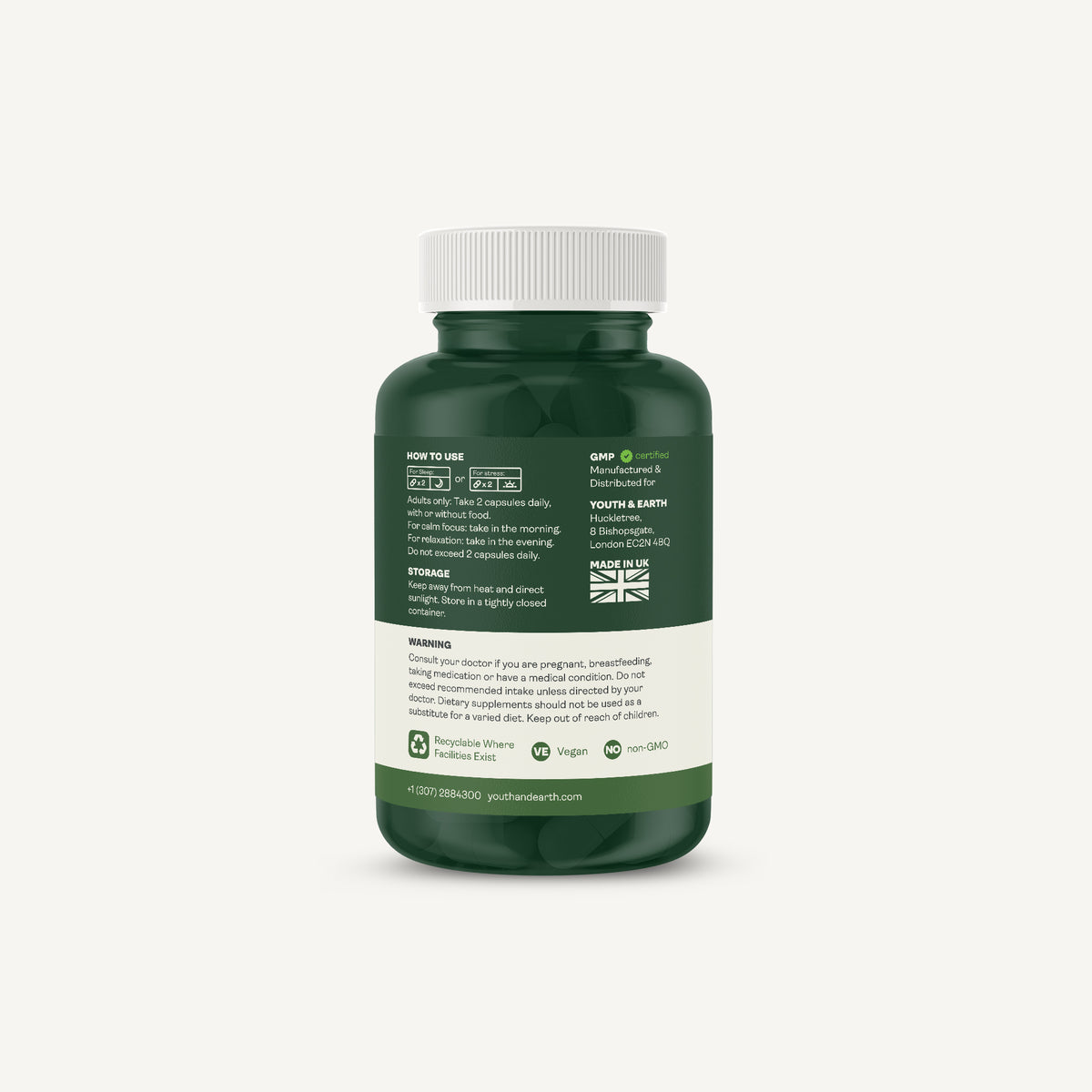 A dark green supplement bottle with a white cap, showing the back label with text, icons, and a small Union Jack, on a light gray background.