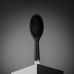 Black hairbrush on a dark gray background