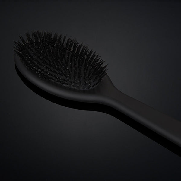 Black hairbrush on a dark background