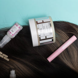Hair care products on a person's head against a light blue background