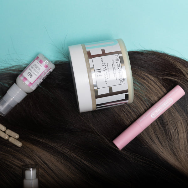 Hair care products on a person's head against a light blue background