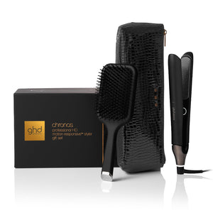 ghd hair styling tools including a paddle brush, hairbrush, and straightener with packaging on a white background
