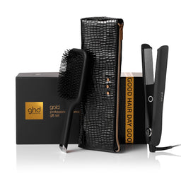 ghd hair care product set with brush, straightener, and box on a white background